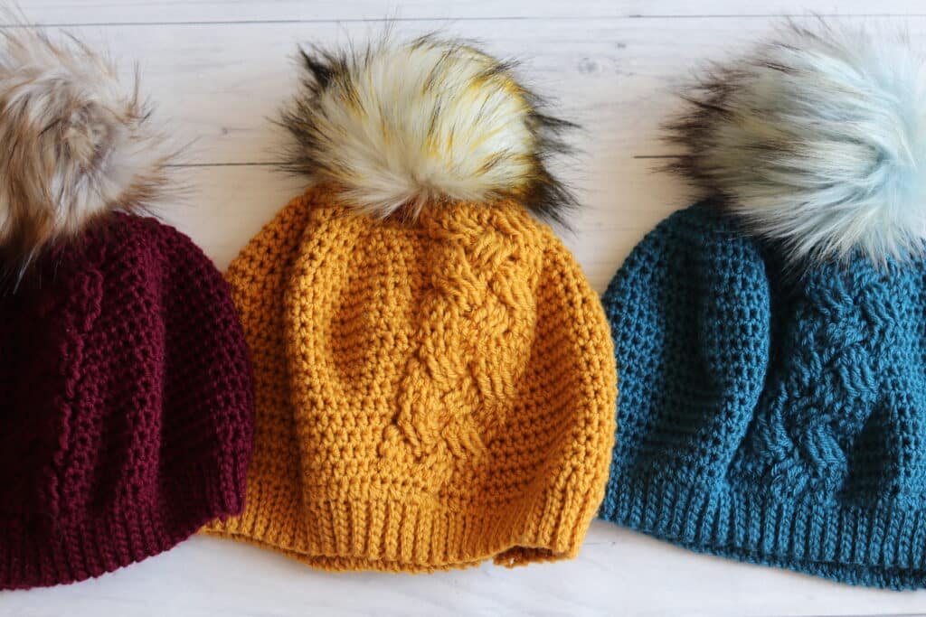 three crochet hats white background red yellow blue