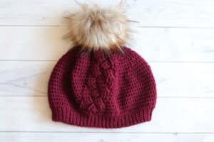 red crochet hat white pompom white background