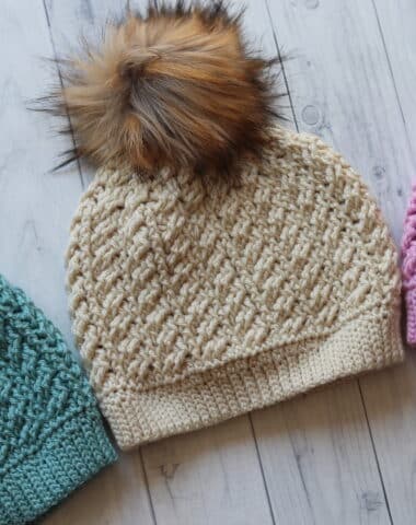three crochet hats displayed on an angle in three different colours