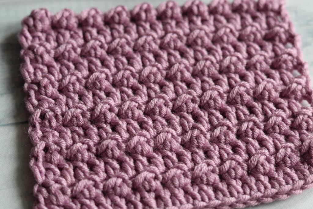 Close up of the crochet floret stitch in a pink yarn