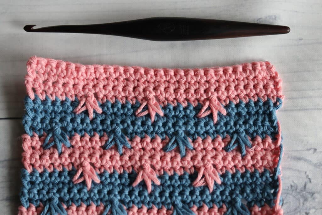 crows foot spike stitch shown in blue and pink yarn