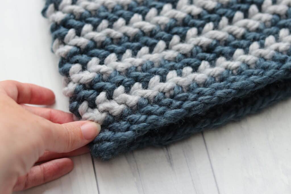 Women's hand holding crochet beanie