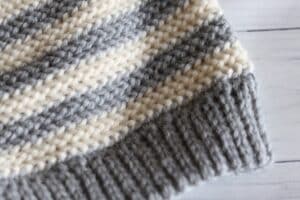 close up of brim on a grey and white crochet beanie