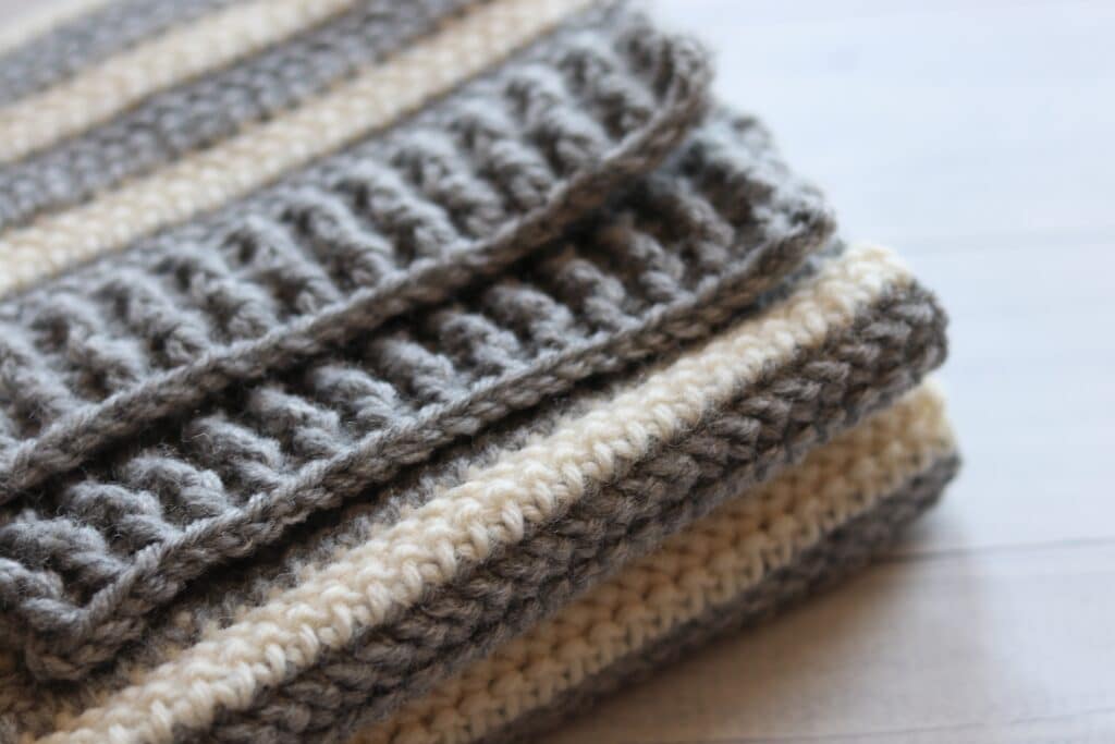 close up of a grey and white crochet scarf