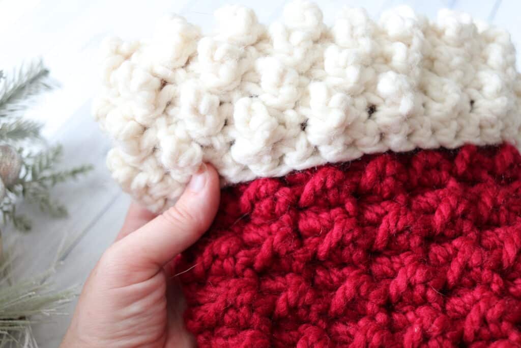 close up of the cuff on a red and white crochet Christmas stocking