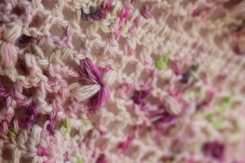 close up of flower on lacy crochet shawl