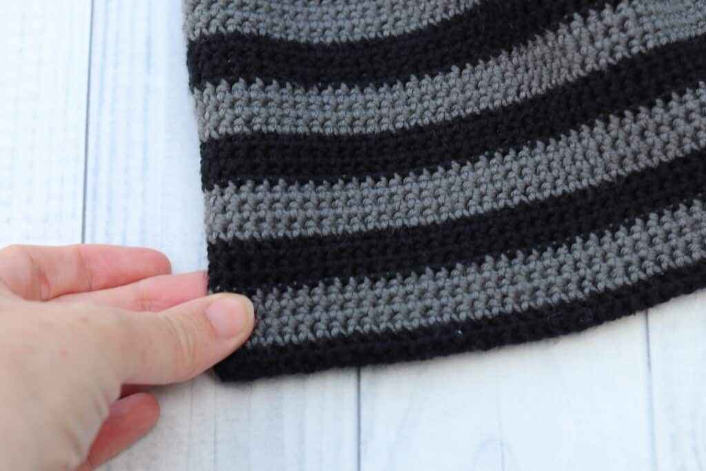 close up of the brim on a grey and black striped crochet beanie for men