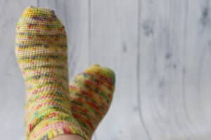 pair of yellow and rainbow crochet socks