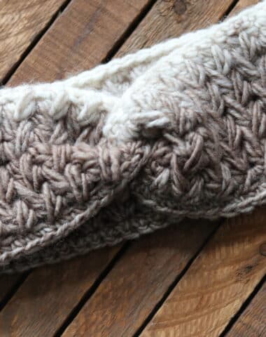 The Feather Stitch Ear Warmer in tan and off white yarn