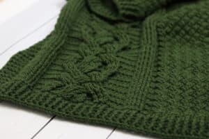 A Green coloured crochet cabled blanket