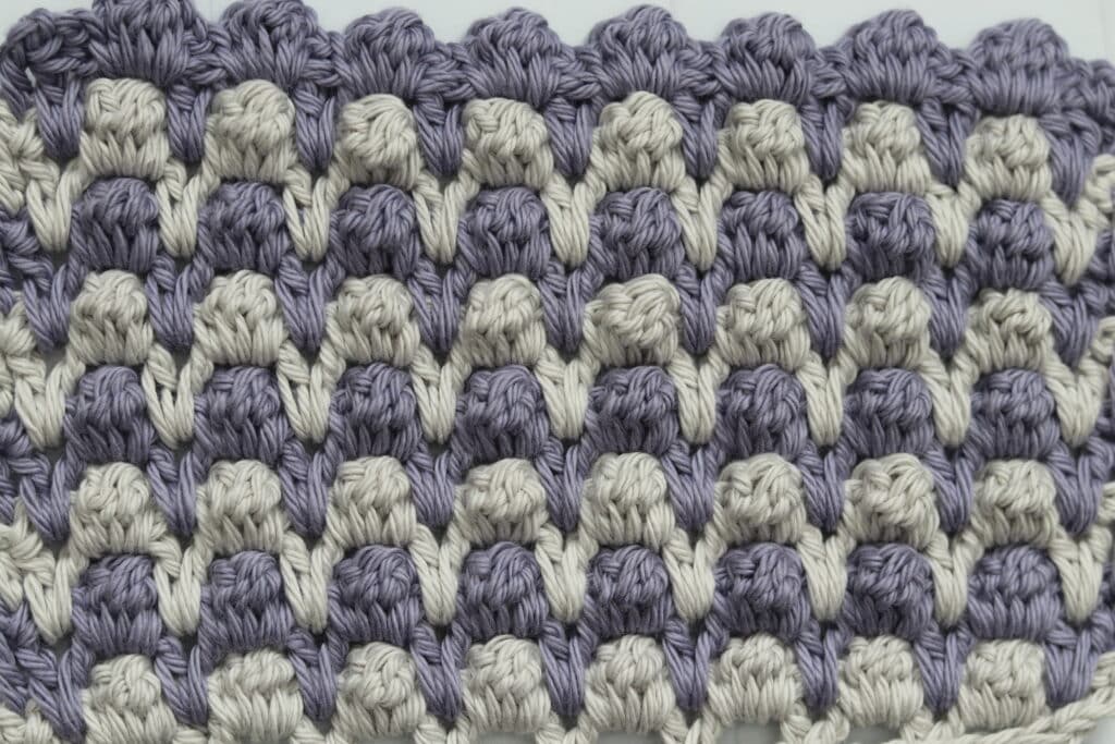 The Interlocking Crochet Cluster Stitch worked in grey and purple yarn