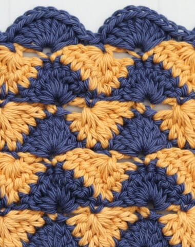A sample of the summer shells crochet stitch worked in blue and gold yarn