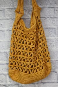 A gold coloured, lacy crochet market bag