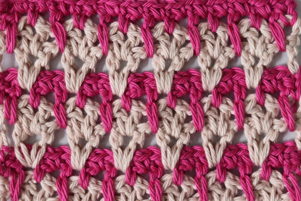 A variation of the crochet v stitch worked in two different shades of pink yarn