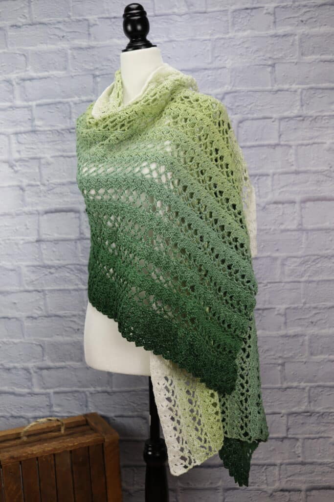 A lacy green crochet rectangular shawl