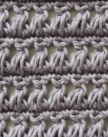 A sample of the crochet triad stitch worked in grey yarn