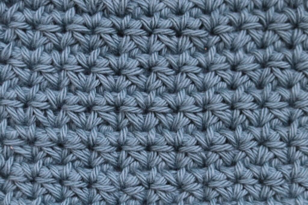 A swatch of the crossed single crochet stitch worked in a blue yarn