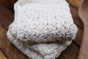 A textured crochet washcloth worked in the extended moss stitch