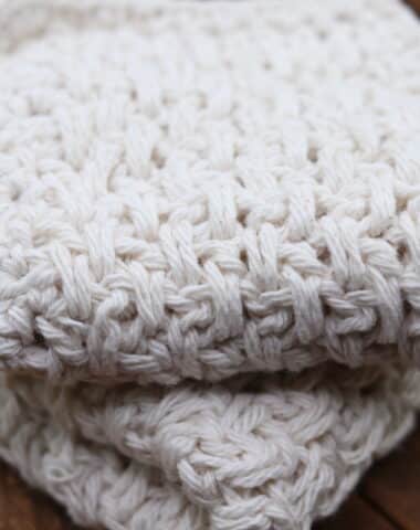 A textured crochet washcloth worked in the extended moss stitch