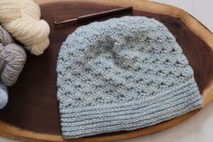 A Crochet Beanie featuring crochet shell stitches worked in a blue yarn