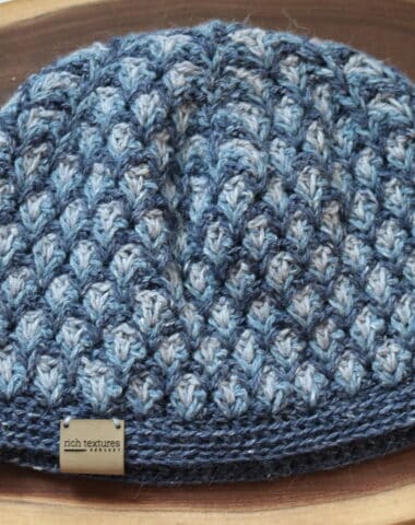 A Crochet Hat featuring three different shades of blue yarn