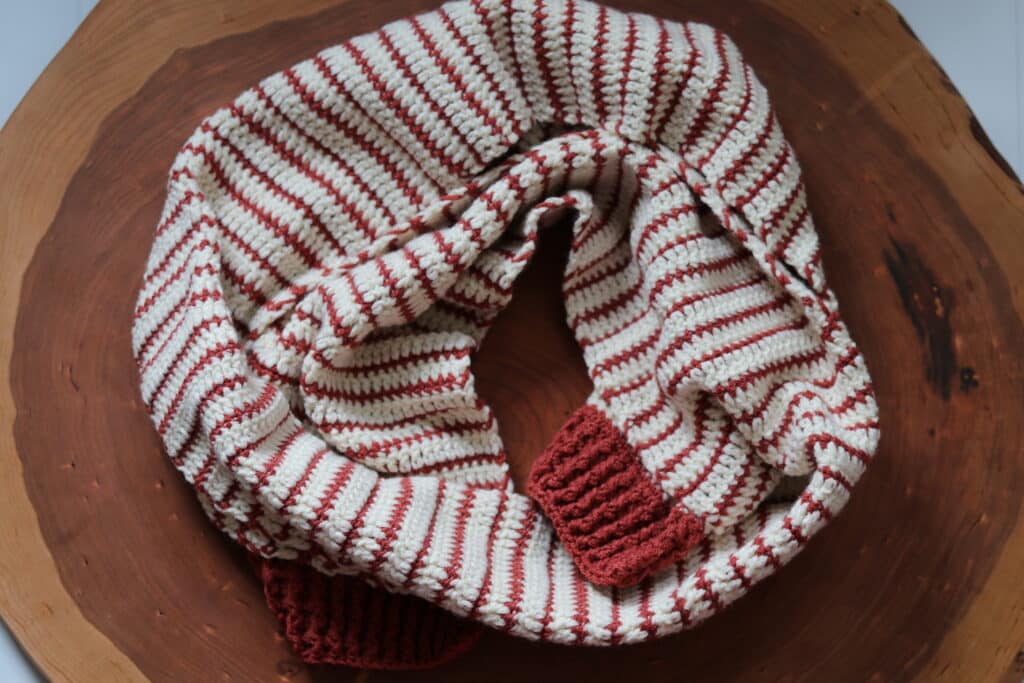 A copper and off white coloured striped crochet scarf