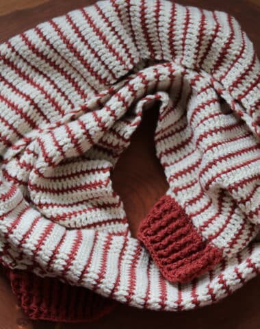A copper and off white coloured striped crochet scarf