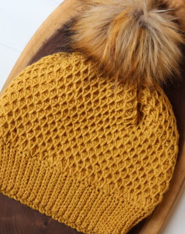 A golden coloured crochet beanie worked in the honeycomb smock stitch