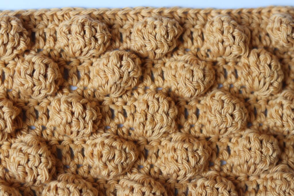 A big bobble crochet stitch worked in a golden coloured yarn