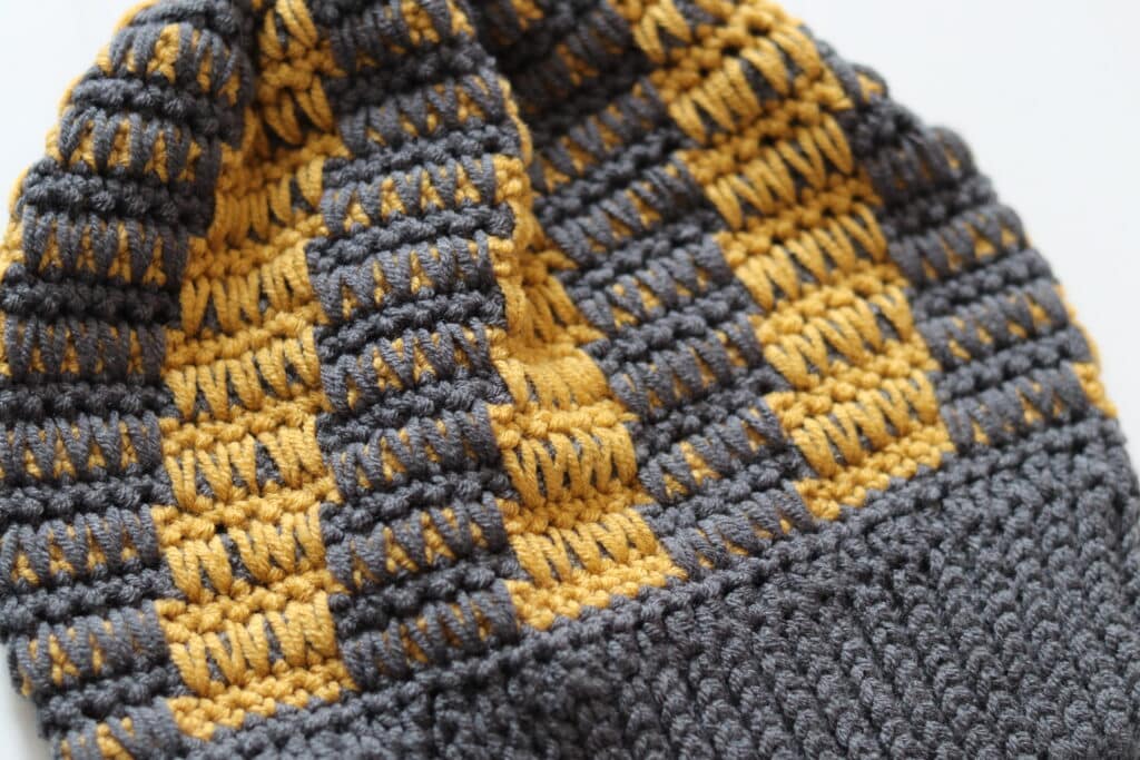 A close up of the yellow and grey crochet Jameson Beanie