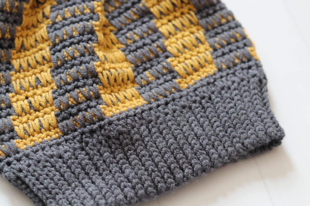 A close up of the brim on the crochet Jameson Beanie worked in a dark grey yarn
