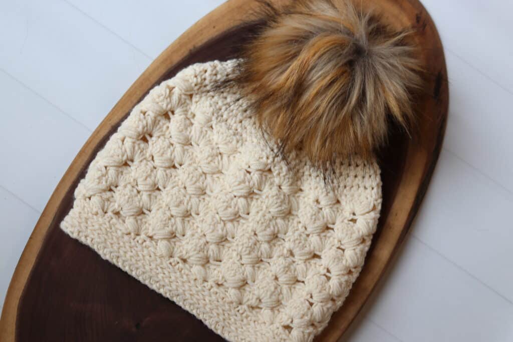 A textured crochet beanie worked in a cream coloured yarn