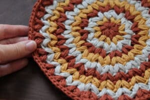 A person holding an edge of the Not so Vintage crochet washcloth