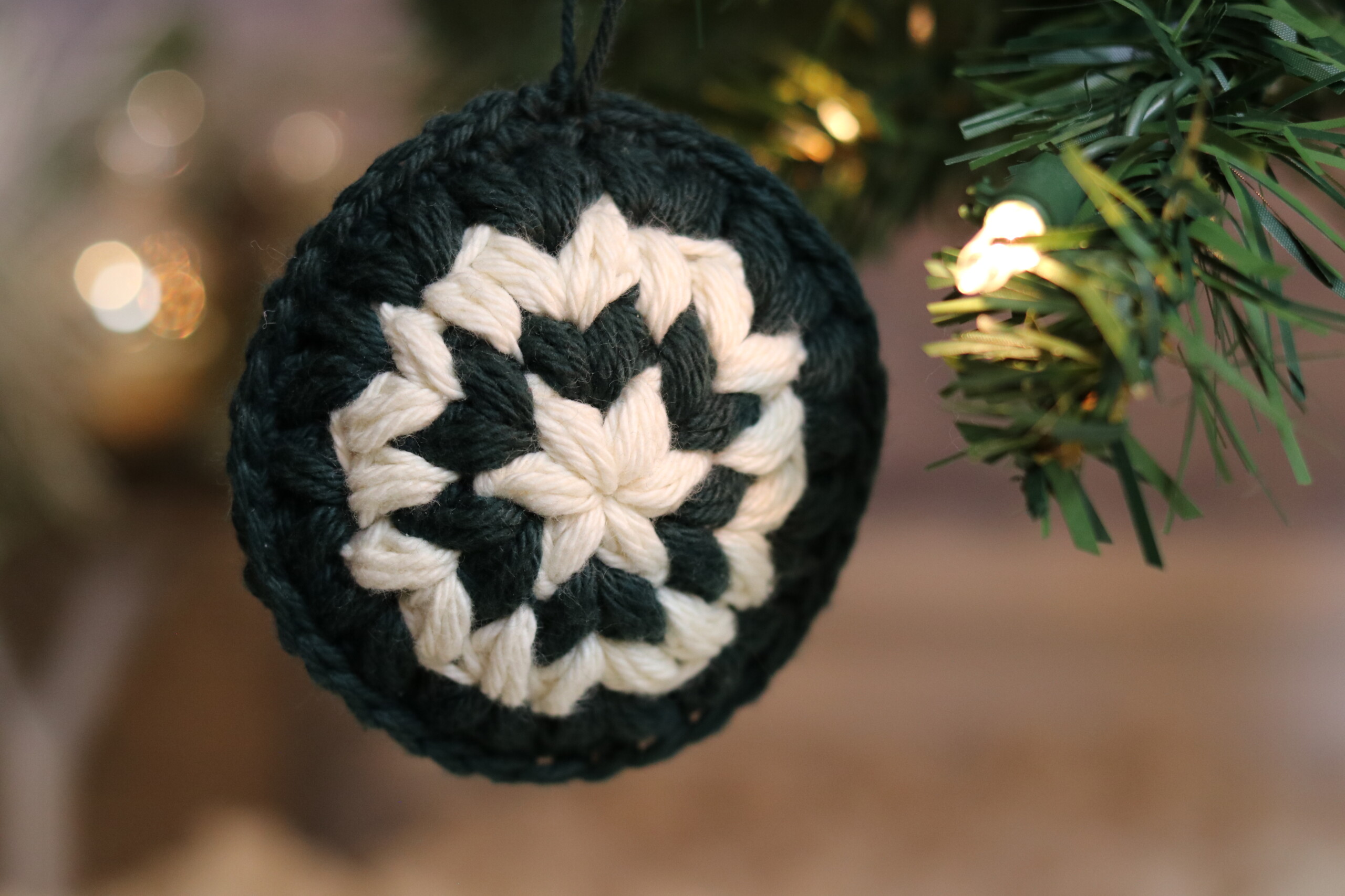 A green and which textured crochet ornament featuring crochet puff stitches