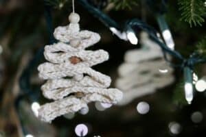A crochet ribbon tree hanging on a Christmas tree