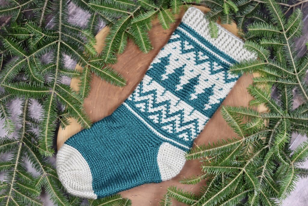 A crochet Christmas Stocking featuring coloured trees