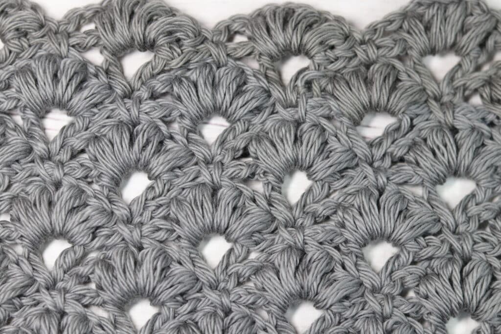 A swatch of the crochet puff shell stitch worked in a grey yarn