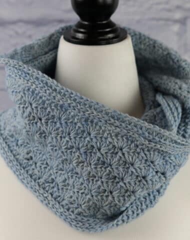 A lacy crochet cowl featuring a solid shell stitch