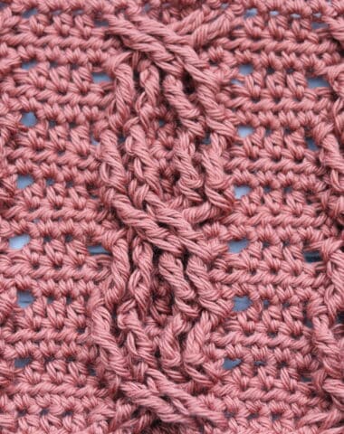 A swatch of a crochet chain link cable worked in a copper coloured yarn