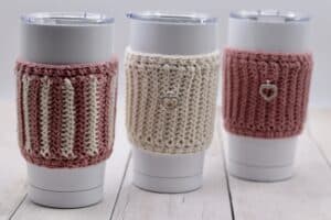 Three crochet cup cozies displayed on three travel mugs