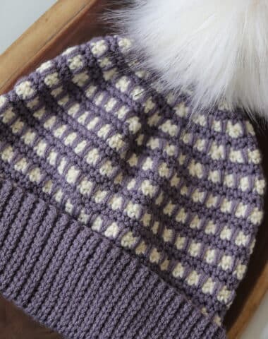 A purple and white crochet beanie