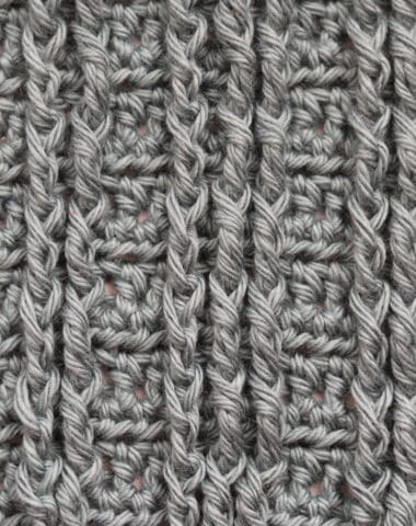 A Swatch of crochet straight cables worked in a grey coloured yarn