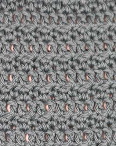 A swatch of the meadows crochet stitch worked in a grey yarn