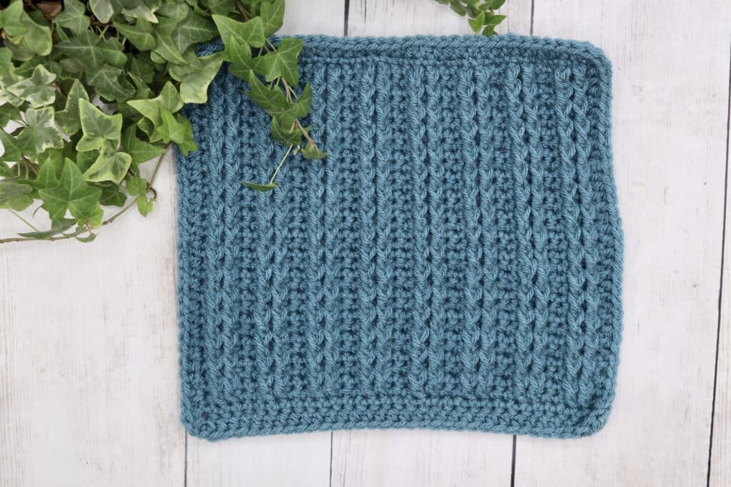 A crochet square featuring straight cables