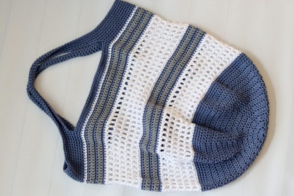 A blue white and grey stripped crochet market bag