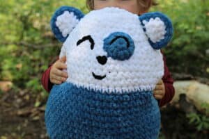 A plush crochet bear worked in blue and white yarn