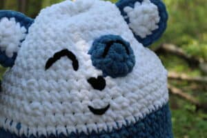 a close up of the face on the crochetuggle Brady the Bear