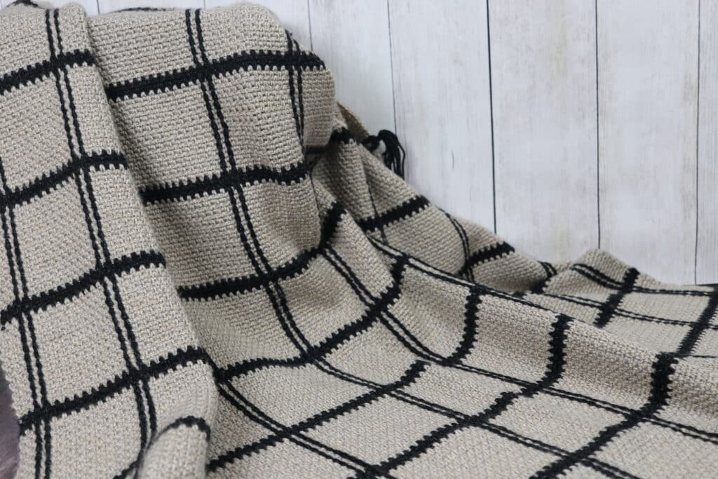 A crochet blanket with a textured square design
