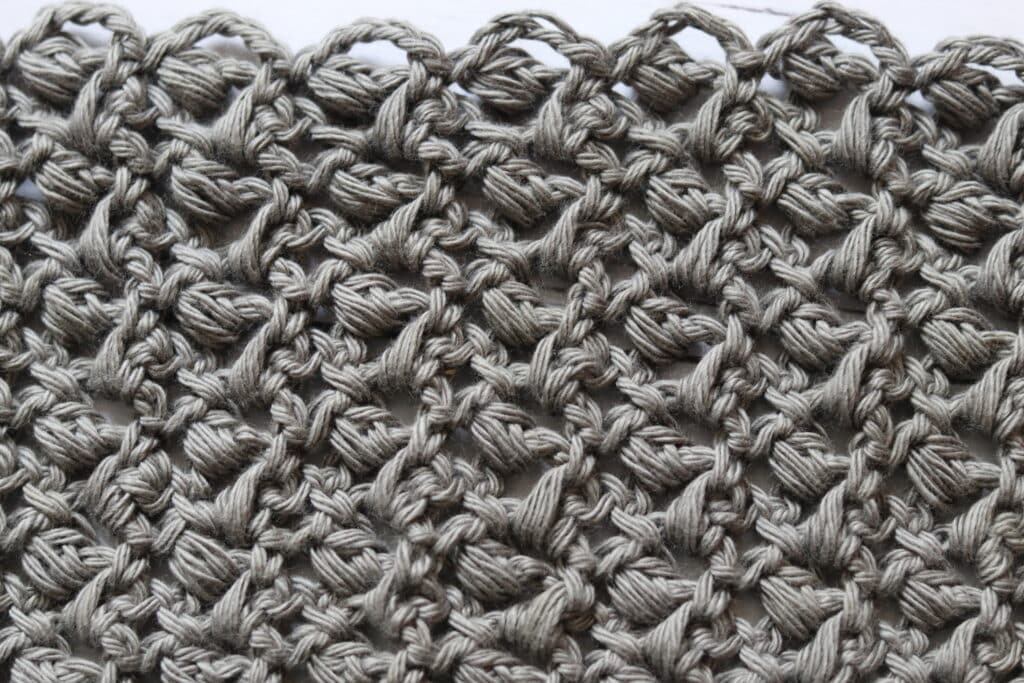 A swatch of the Little Rocks Crochet Stitch worked in a grey yarn
