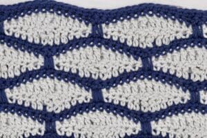 The crochet tile brick stitch worked in blue and grey yarn